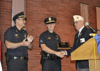 Sgt. Brandon Murphy, Center, receives award from American Legion member. Chief David Mara, left, applauds.