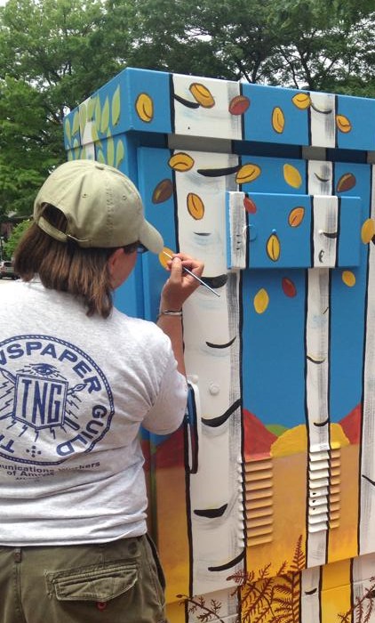 Nancy Welsh puts the finishing touches on her public art project, entitled, "Reasons for Seasons," in June of 2014.