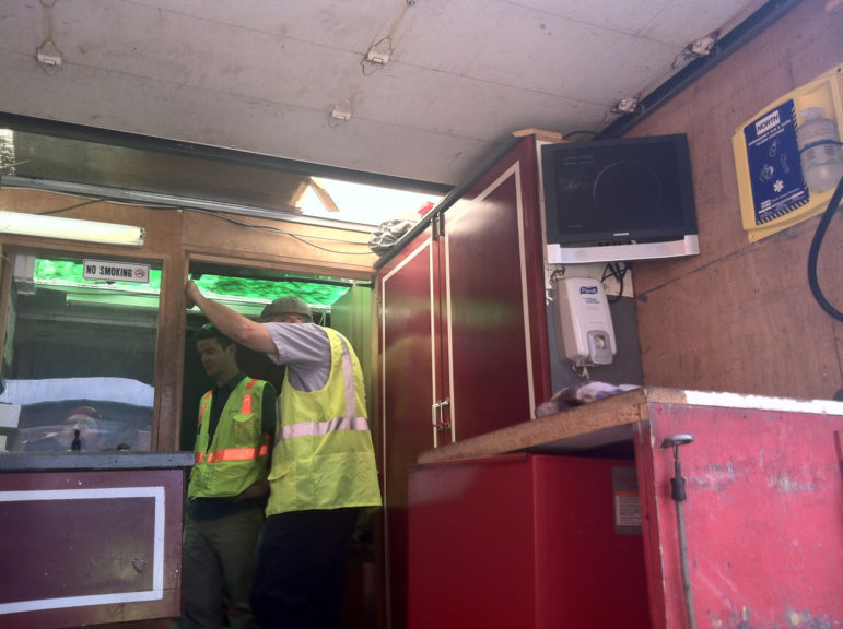 A city work crew looks at an image transmitted by a small camera lowered into a broken sewer pipe.