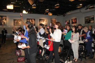 50 new U.S. citizens wave their flags after taking the oath.