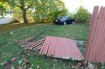 A car involved in a crash with a police cruiser knocked down fence before coming to rest in someone's yard.
