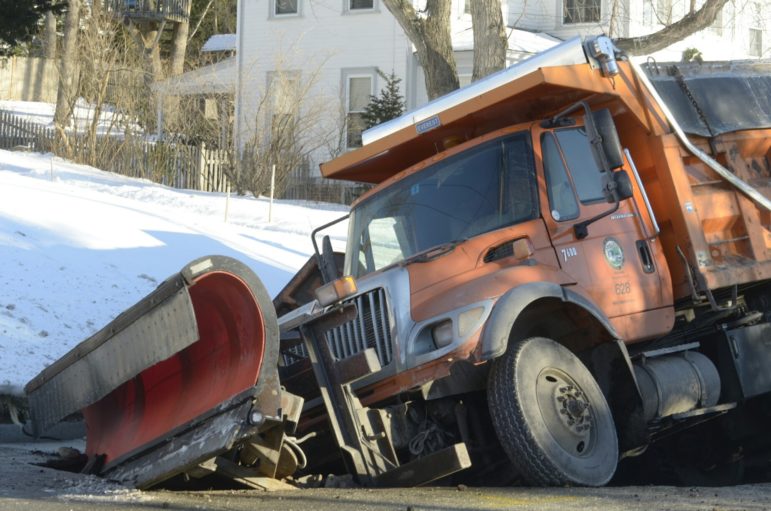 City sander truck stuck in a sinkhole on Kennard Street following water main break.