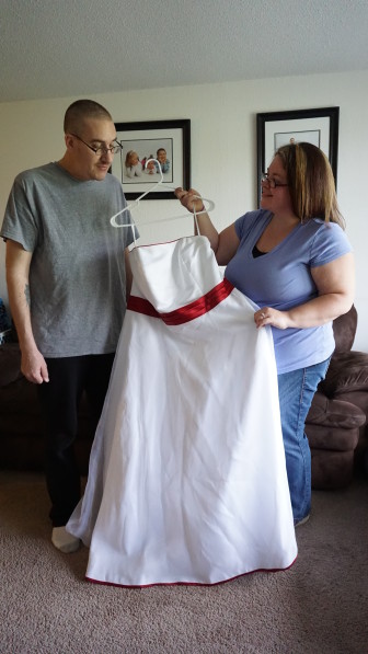 Melissa Fox takes a last look at her wedding dress before she and her kids paint it with a Superman theme as a tribute to her husband Steve, battling cancer.