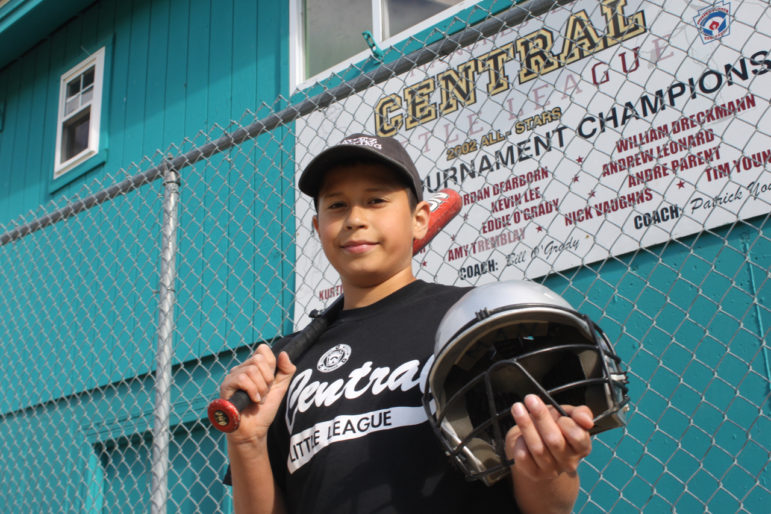 Michael Negron, 12, shows off some of the donated equipment from Project Play. He has been playing baseball in Manchester since he was 5. 