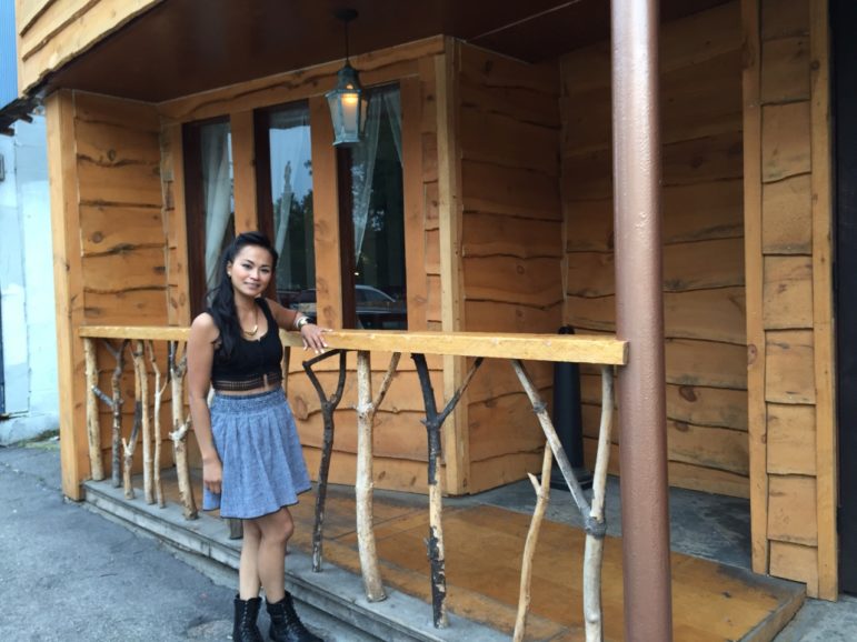 Sophea Yay next to the unique railing, which is a bunch of branches from her yard.