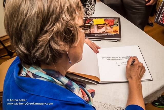 Author Becky Field signs books during the Sept. 17 launch of Different Roots, Common Dreams, in Concord.