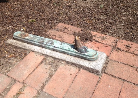 A piece of a bench left behind after vandals struck in July.
