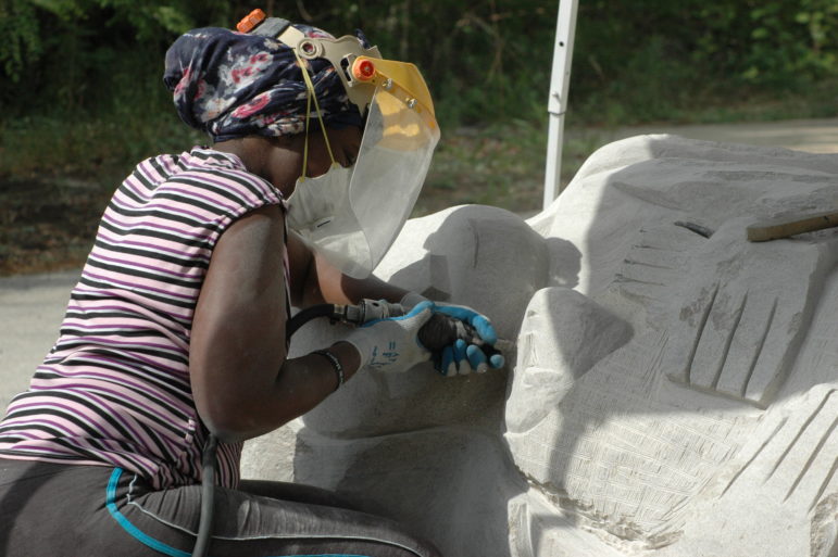 Zimbabwe sculptor Ennica Mukomberanwa works on Mother and Child during 2015 International Sculpture Symposium.