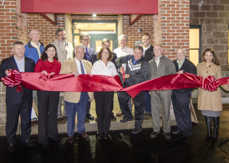 Dick Anagnost, with scissors, cuts the ribbon on the new FIT shelter and community center, flanked by city, state and U.S. dignitaries, including Sen. Kelly Ayotte, R-NH, and Mayor Ted Gatsas.