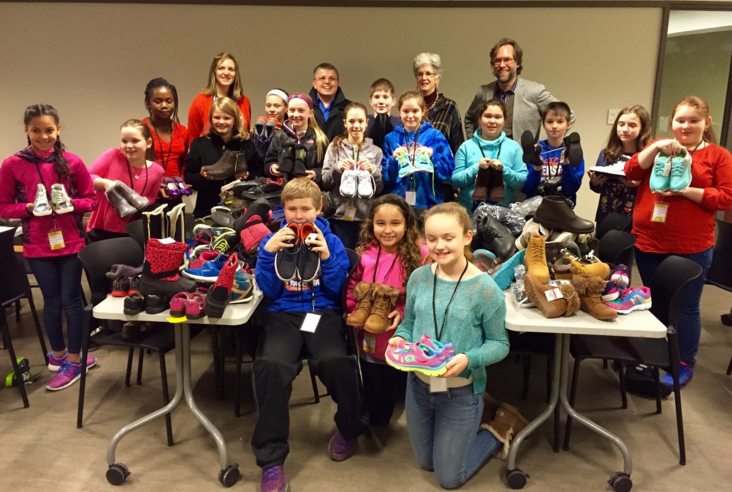 The Webster School student council members pose with Currier Museum of Art Director & CEO Susan Strickler and staff while they sort shoes on January 19.