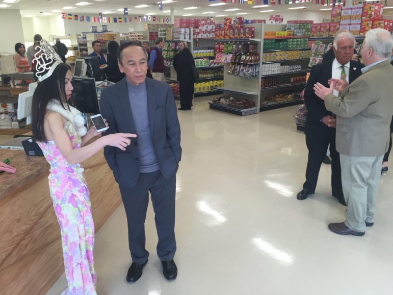 Guests mingle and sample food during a ribbon-cutting celebration at Saigon Asian Market.