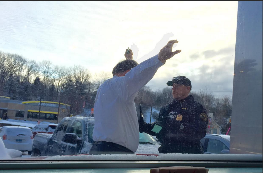 A Secret Service agent does a security check on a customer outside the Airport Diner on Tuesday.