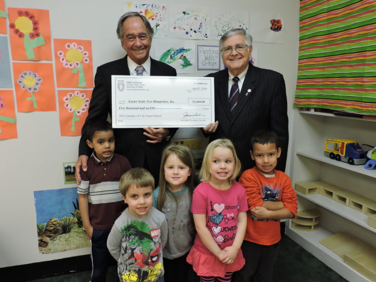 Easter Seals CEO Larry Gammon, left, with Richard Rawlings and some of the many children of Easter Seals, during check presentation.