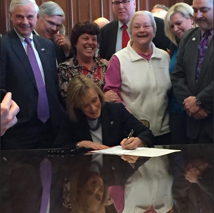 Gov. Maggie Hassan signs NH Health Protection Plan into law.