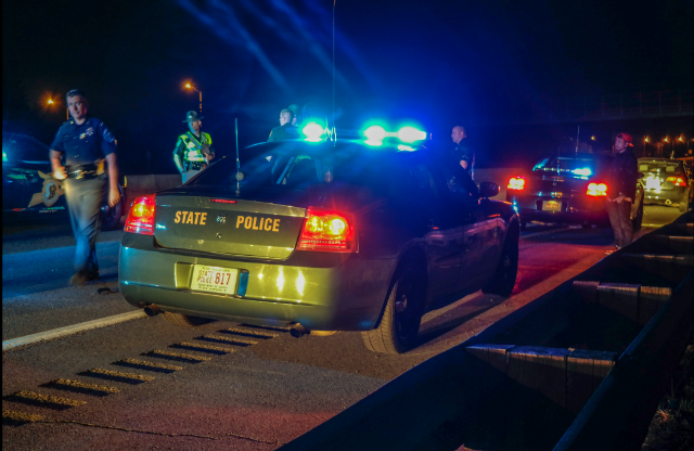 State Police gather evidence from around cruiser of Trooper struck early Sunday morning.