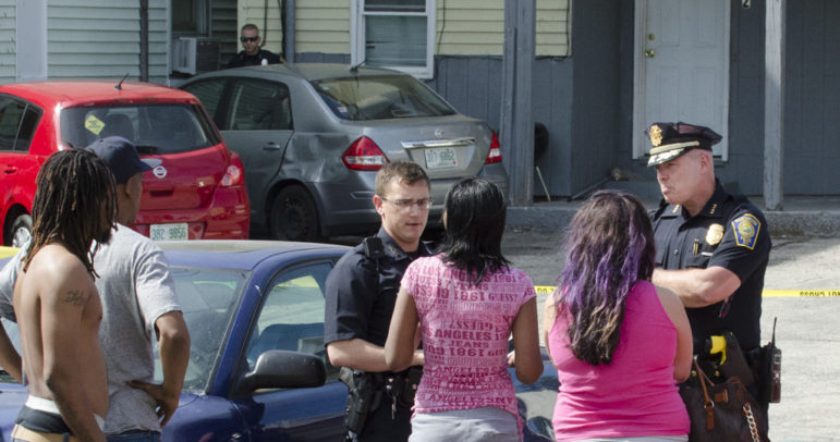 Chief Nick Willard, right, speaks with witnesses at the scene of a fatal shooting June 1.