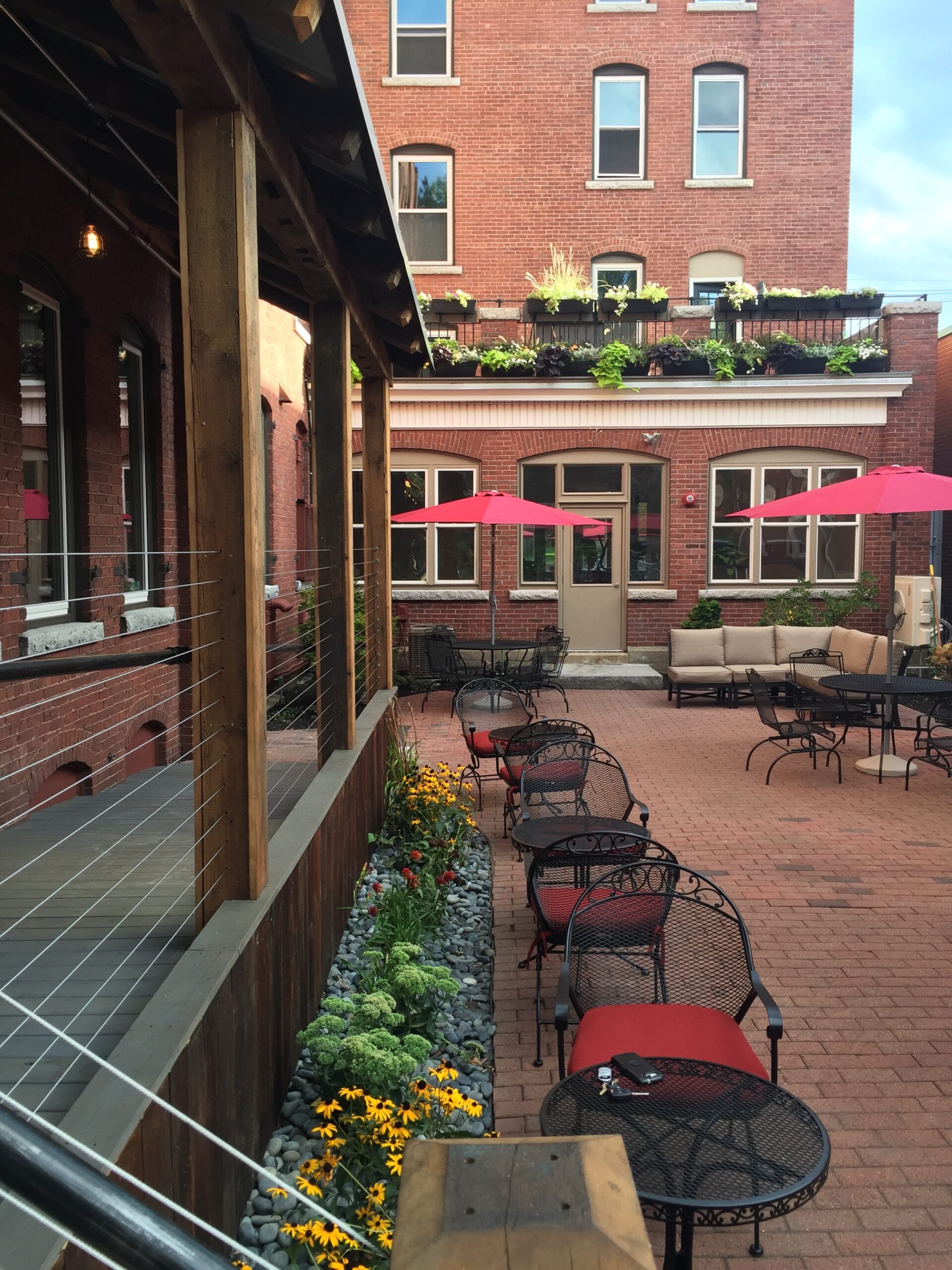 Courtyard view includes outdoor seating, and a rooftop deck extending from a second-story apartrment.