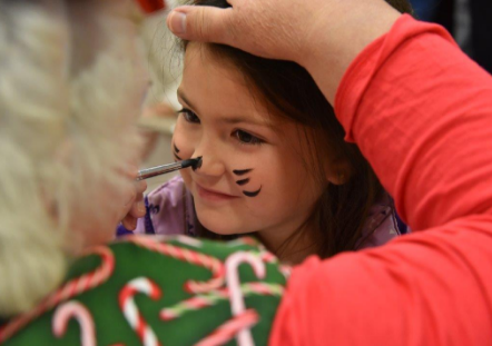 Dakota Bunnell having her face painted like the Cat in the Hat.