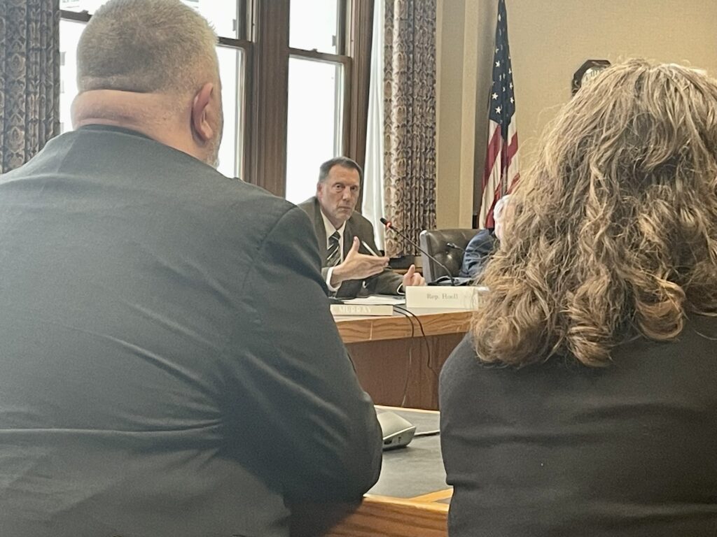 Rep. J.R. Hoell, a Dunbarton Republican, questions Joe Ribsam, director of the Division for Children, Youth, and Families, and Morissa Henn, associate commissioner at the Department of Health and Human Services, about legislation that would replace the Sununu Youth Services Center.Photo/Annmarie Timmins