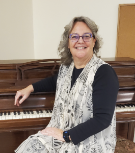 Manchester Community Music School (MCMS) seated at a piano in a photo by Keith Spiro.