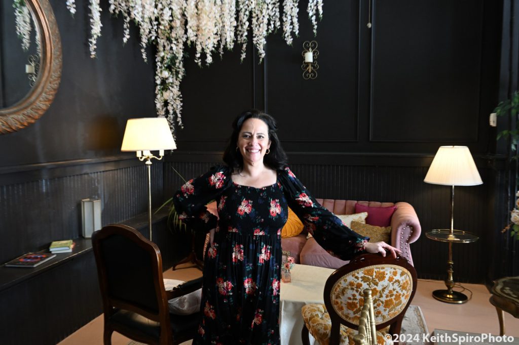 Honey Cup cafe and tearoom owner Mara Witt standing amidst the elegance in a photo by Keith Spiro. 