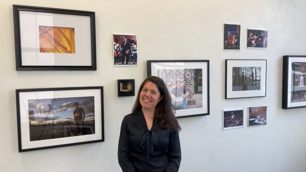 Together show is seen as a partial backdrop to curator Amy Regan in a photo capture from the introductory video.