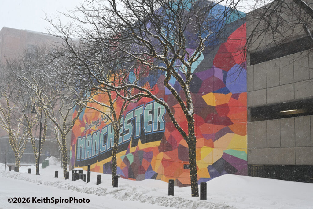 Blizzard conditions showing in Keith Spiro Photo of the Greetings from Manchester mural by artist James Chase; in a snowstorm on Feb 23, 2026.